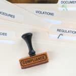 compliance rubber stamp on folders marked policies