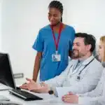 Behavioral health care team reviewing electronic health records on a clinic computer