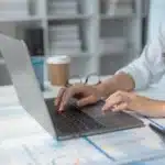 Billing specialist reviewing behavioral health insurance billing reports on a laptop